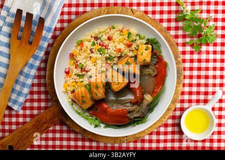 Gericht mit gebackenem Lachs, Paprika und Couscous-Salat. Tisch mit Blick von oben mit weihnachtsdekoration. Stockfoto