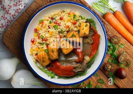 Gericht mit gebackenem Lachs, Paprika und Couscous-Salat. Tisch mit Blick von oben mit weihnachtsdekoration. Stockfoto