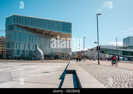 Oslo, Norwegen - 13. April 2024: Menschen, die spazieren gehen und entspannen in der Oper Oslo, Einem modernen architektonischen Gebäude mit schrägem Dach am Ufer. Stockfoto