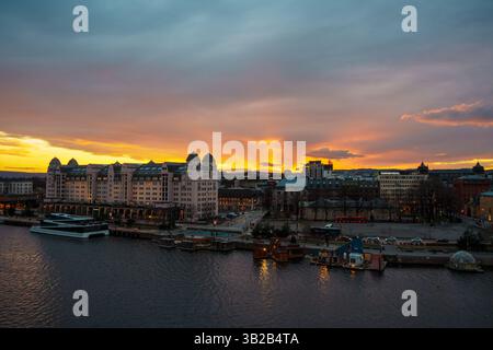 Oslo, Norwegen - 13. April 2024: Eine Landschaft des Osloer Hafens, in der Menschen spazieren gehen und sich entspannen können. Die Szene wird während der Dämmerung eingestellt. Stockfoto