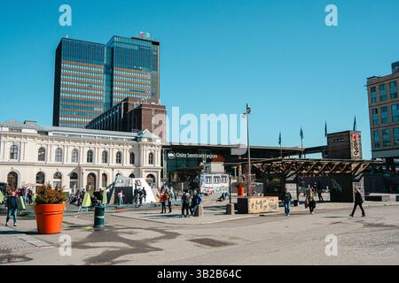Oslo, Norwegen - 13. April 2024: Ein städtischer Platz in Oslo, Norwegen, mit modernen und historischen Gebäuden. Die Leute laufen herum und genießen die Sonne Stockfoto