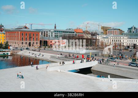 Oslo, Norwegen - 13. April 2024: Menschen, die spazieren gehen und entspannen in der Oper Oslo, Einem modernen architektonischen Gebäude mit schrägem Dach am Ufer. Stockfoto