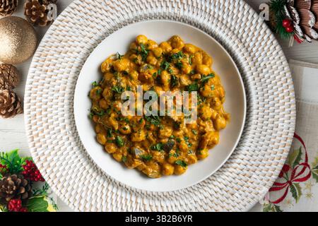 Kichererbsencurry mit Auberginen und Gemüse. Tisch mit Blick von oben mit weihnachtsdekoration. Stockfoto