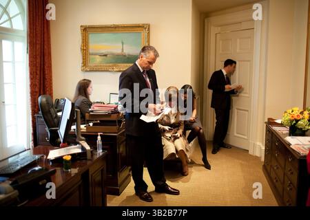 24. November 2009 - Washington, DC, Vereinigte Staaten - der stellvertretende Direktor von Oval Offfice Operations Brian Mosteller hört den Fortschritt eines Treffens im Oval Office während des Staatsbesuchs von Premierminister Manmohan Singh von Indien. Im Äußeren Oval warten auch, von links, Personal Secretary Katie Johnson, Chief of Protocol Capricia Marshall, Huma Abedin, Beraterin von Außenministerin Hillary Clinton und US-Botschafter in Indien Timothy Roemer, 24. November 2009. (Offizielles Foto des Weißen Hauses von Pete Souza). Dieses offizielle Foto des Weißen Hauses wird nur für Publi zur Verfügung gestellt Stockfoto