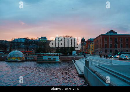 Oslo, Norwegen - 13. April 2024: Eine Landschaft des Osloer Hafens, in der Menschen spazieren gehen und sich entspannen können. Die Szene wird während der Dämmerung eingestellt. Stockfoto