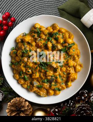 Kichererbsencurry mit Auberginen und Gemüse. Tisch mit Blick von oben mit weihnachtsdekoration. Stockfoto