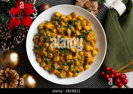 Kichererbsencurry mit Auberginen und Gemüse. Tisch mit Blick von oben mit weihnachtsdekoration. Stockfoto