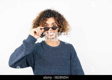 Porträt eines jungen Mannes aus dem Mittleren Osten mit lockigem Haar, der eine Sonnenbrille trägt Stockfoto