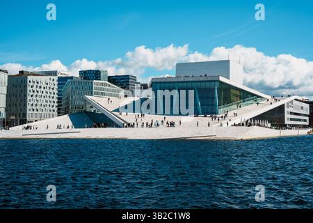 Oslo, Norwegen - 13. April 2024: Menschen, die spazieren gehen und entspannen in der Oper Oslo, Einem modernen architektonischen Gebäude mit schrägem Dach am Ufer. Stockfoto