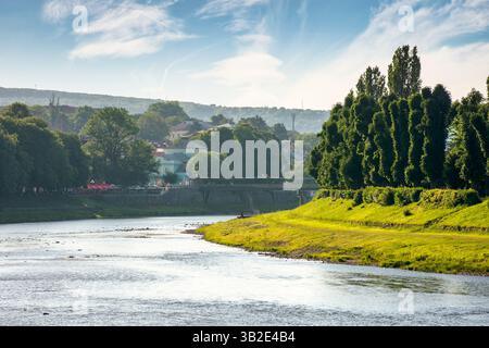 Uferdamm der uzh im Morgenlicht. Wunderschöne urbane Landschaft im Sommer. linden Gasse am linken Ufer. Malerischer Blick auf die Innenstadt von uschhorod Stockfoto