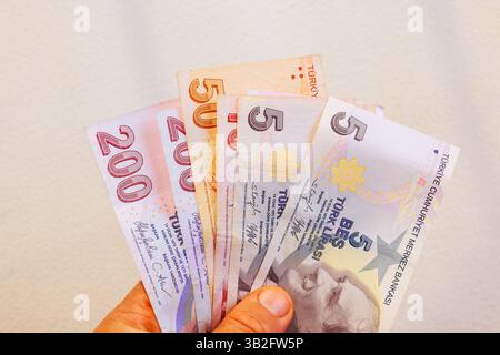 Die Hand enthält verschiedene türkische Banknoten, darunter 200, 50, 5 Lira gemischtes Bargeld in türkischer Währung Stockfoto