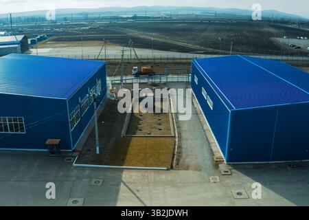 Zwei große blaue Hangars aus Metallprofil. Gewelltes Blau. Stockfoto