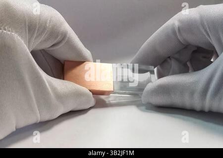 Flash-Laufwerk in den Händen in weißen Handschuhen. Speicherung von Informationen auf einem Flash-Laufwerk. Stockfoto