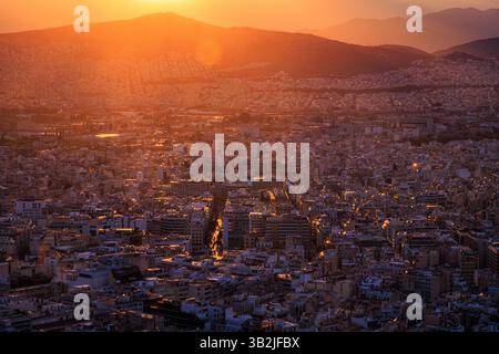 Die Sonne untergeht über der griechischen Hauptstadt Athen, die Stadt breitet sich in der Ferne aus. Vom höchsten Gipfel, dem Lycabettus, in Kolonaki aus gesehen. Stockfoto