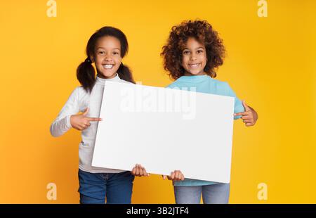 Mädchen, die ein leeres Banner für deine SMS halten Stockfoto