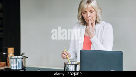 Computer, Kochen und Seniorin in der Küche des modernen Hauses für gesundes oder Diät-Abendessen. Nahrung, Technologie und ältere Frau, die eine vorbereitet Stockfoto