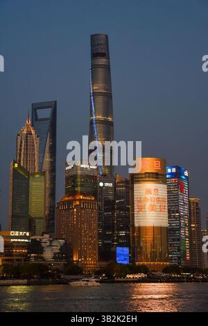Shanghai, China - 1. April 2025: Abendliche Skyline des Stadtteils Pudong mit beleuchtetem Shanghai Tower, Shanghai World Financial Center und Jin Mao Stockfoto