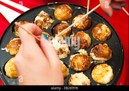 Kochen Takoyaki: Köstliche Oktopusbällchen, ein berühmtes japanisches Street Food. Stockfoto