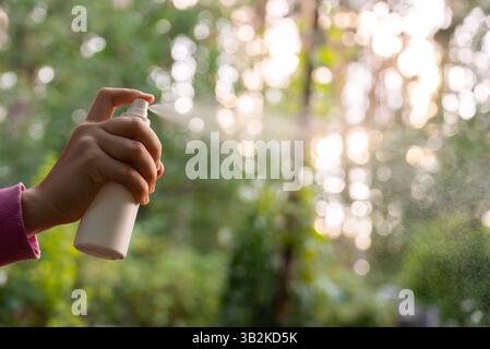 Mit der Hand Insektenschutzmittel auftragen, um Fliegen, Wanzen und Mücken auf der Haut draußen zu töten. Malaria-zika-Virus und Denguefieberprophylaxe. Schutzmaßnahmen Stockfoto