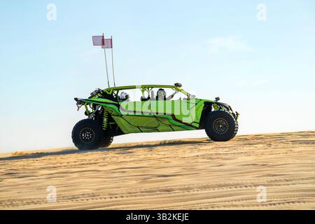 Ein Buggy fährt mit hoher Geschwindigkeit über eine Sanddüne in der Wüste. Arabische Unterhaltung in der Wüste. 4x4, Fahren in Geländefahrzeugen. Geländesport Stockfoto