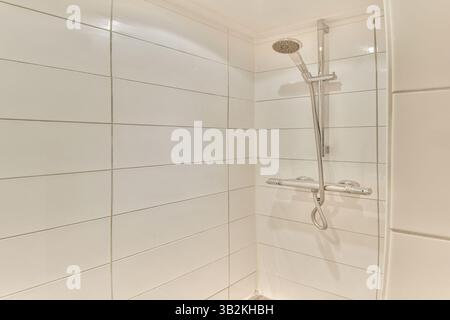Ein sauberes und minimalistisches Design einer modernen Duschkabine mit eleganten Fliesen und einer modernen Duschvorrichtung, ideal für die Renovierung des Badezimmers. Stockfoto