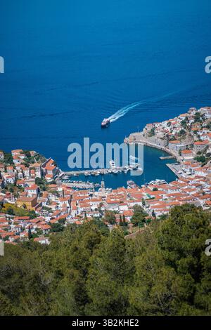 Blick aus der Vogelperspektive auf den Haupthafen auf der Insel Hydra in Griechenland mit roten Häusern, die um den Hafen gruppiert sind. Stockfoto