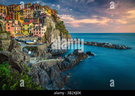 Eines der berühmtesten und schönsten Dörfer der Welt mit farbenfrohen Häusern am Meer auf den Klippen bei Sonnenuntergang, Manarola, Cinque Terre, Ligurien, Italien Stockfoto