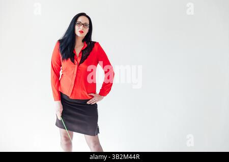 Brünette Lehrerin in rotem Business-Anzug mit Zeiger auf weißem Hintergrund Stockfoto