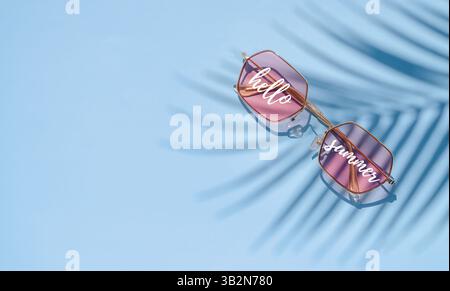 Palmenschatten und Sonnenbrille auf Blau. Sommerwerbung oder tropisches Stimmungskonzept Stockfoto