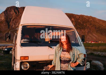 Lächelnde Frau, die vor dem Wohnmobil steht Stockfoto