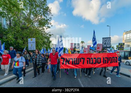 Haifa, Israel - 26. April 2025: Menschen mit verschiedenen Schildern und Flaggen nehmen an einer Protestkundgebung Teil, die die Beendigung des Krieges und die Vollendung der Geiselnahme fordert Stockfoto