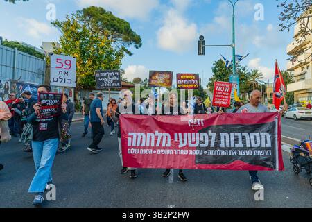 Haifa, Israel - 26. April 2025: Menschen nehmen an einem protestmarsch (Friedensaktivistengruppe) Teil, mit verschiedenen Zeichen und Fahnen, die zum Ende des Krieges aufrufen Stockfoto