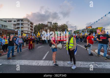 Haifa, Israel - 26. April 2025: Menschen mit verschiedenen Schildern und Flaggen nehmen an einer Protestkundgebung Teil, die die Beendigung des Krieges und die Vollendung der Geiselnahme fordert Stockfoto