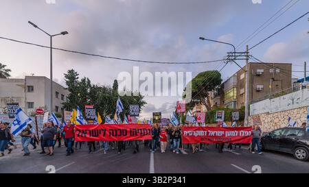 Haifa, Israel - 26. April 2025: Menschen mit verschiedenen Schildern und Flaggen nehmen an einer Protestkundgebung Teil, die die Beendigung des Krieges und die Vollendung der Geiselnahme fordert Stockfoto