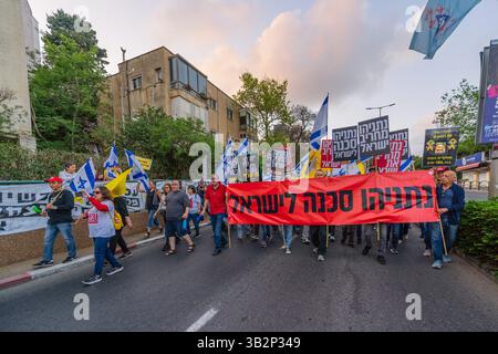 Haifa, Israel - 26. April 2025: Menschen mit verschiedenen Schildern und Flaggen nehmen an einer Protestkundgebung Teil, die die Beendigung des Krieges und die Vollendung der Geiselnahme fordert Stockfoto