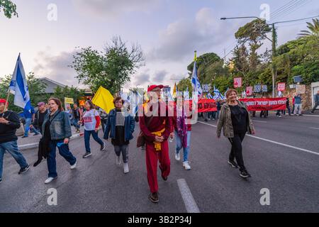 Haifa, Israel - 26. April 2025: Menschen mit verschiedenen Schildern und Flaggen nehmen an einer Protestkundgebung Teil, die die Beendigung des Krieges und die Vollendung der Geiselnahme fordert Stockfoto