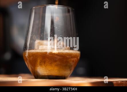 Ein erfrischendes Glas Bier steht derzeit auf einem rustikalen Holztisch, der von jedem, der vorbeikommt, genossen werden kann Stockfoto