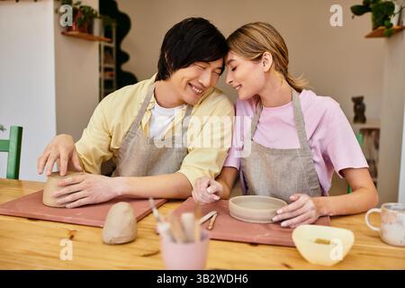 Ein junges Paar bastelt in einem charmanten Studio Töpferei und teilt Freude und Kreativität. Stockfoto