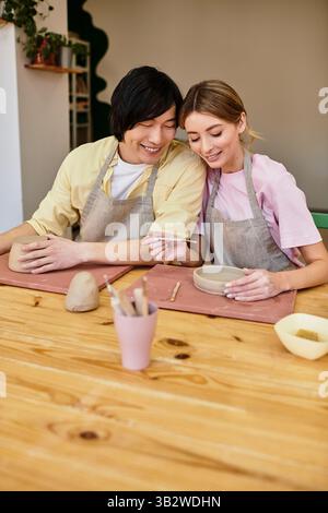 Ein junges Paar genießt eine kreative Töpferstunde, teilt Lachen und künstlerische Momente. Stockfoto