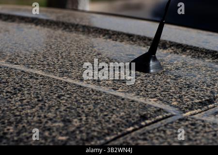Nahaufnahme von gelbem Sahara-Sand und Regen auf einem schwarzen Auto Stockfoto