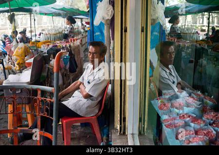 Dez 16, 2015 - Bangkok, Thailand - Mann Verkäufer von Lotusblumen in Pak Khlong Talat, Blumenmarkt , Bangkok, Thailand. Pak Khlong Talat ist ein Markt in Bangkok, Thailand, der Blumen, Obst und Gemüse verkauft. Es ist der wichtigste Blumenmarkt in Bangkok und wurde für die Einwohner Bangkoks als „Ort der symbolischen Werte“ bezeichnet. Es liegt an der Chak Phet Road und angrenzenden Seitenstraßen, in der Nähe der Memorial Bridge. Obwohl der Markt rund um die Uhr geöffnet ist, ist er vor Sonnenaufgang am meisten beschäftigt, wenn Boote und LKW mit Blumen aus den nahe gelegenen Provinzen ankommen. Der Markt hat eine lange Geschichte. Während der Herrschaft von RAM Stockfoto