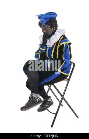 Schwarzer Peter für typische Sinterklaas Urlaub auf Stuhl sitzend und denken Stockfoto