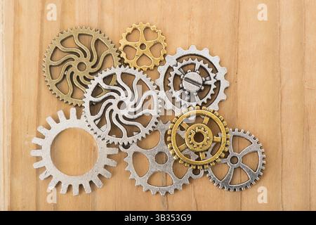 Industrieräder in Kupfer und Silber auf Holzhintergrund Stockfoto