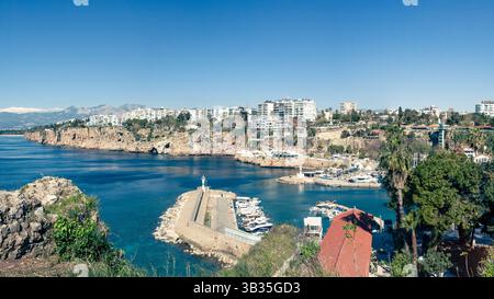 Malerischer Blick auf den historischen Hafen von Antalyas Altstadt (Kaleici), Türkei. Das Bild zeigt den Yachthafen umgeben von dramatischen Klippen und modernen Gebäuden Stockfoto