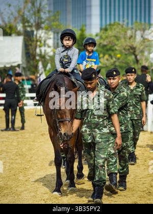 13. Januar 2018 - Bangkok, Bangkok, Thailand - thailändische Soldaten helfen Kindern auf thailändischen Kavallerie-Pferden während der Aktivitäten zum Kindertag im 2. Kavallerie-Lager der Königsgarde der Royal Thai Army im Zentrum von Bangkok. Der Kindertag wird auf Thailändisch „Wan DEK“ genannt. Viele Regierungsbüros und Militärbasen bieten spezielle Aktivitäten für Kinder an, ebenso wie Einkaufszentren. (Kreditbild: © Sean Edison via ZUMA Wire) Stockfoto