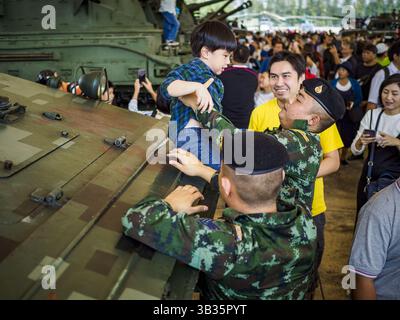 13. Januar 2018 - Bangkok, Bangkok, Thailand - thailändische Soldaten helfen einem Kind, während der Aktivitäten zum Kindertag im 2. Kavallerie-Lager der Königsgarde der Royal Thai Army im Zentrum von Bangkok von einem gepanzerten persönlichen Träger vom Typ 85 zu springen. Der Kindertag wird auf Thailändisch „Wan DEK“ genannt. Viele Regierungsbüros und Militärbasen bieten spezielle Aktivitäten für Kinder an, ebenso wie Einkaufszentren. Thailand kaufte den Typ 85 von China. (Kreditbild: © Sean Edison via ZUMA Wire) Stockfoto