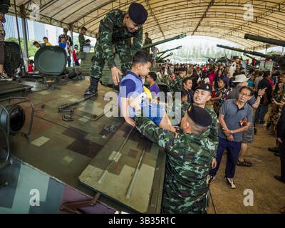 13. Januar 2018 - Bangkok, Bangkok, Thailand - thailändische Soldaten helfen einem Kind, während der Aktivitäten zum Kindertag im 2. Kavallerie-Lager der Königsgarde der Royal Thai Army im Zentrum von Bangkok von einem gepanzerten persönlichen Träger vom Typ 85 zu springen. Der Kindertag wird auf Thailändisch „Wan DEK“ genannt. Viele Regierungsbüros und Militärbasen bieten spezielle Aktivitäten für Kinder an, ebenso wie Einkaufszentren. Thailand kaufte den Typ 85 von China. (Kreditbild: © Sean Edison via ZUMA Wire) Stockfoto