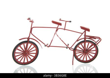 Ein rotes Fahrrad mit Sitzen und Pedalen für zwei Fahrer, einer hinter dem anderen isoliert auf weißem Hintergrund Stockfoto