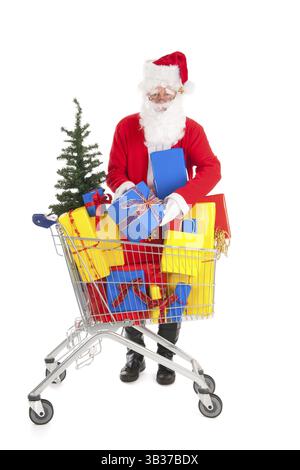 Santa Claus setzen ein Geschenk in den Warenkorb Einkaufswagen voller Luxus präsentiert und Baum Stockfoto