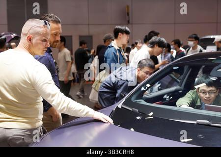 Ausländische Besucher erfahren am Stand von Avatr mehr über das neue Energiefahrzeug. Shanghai, China. 26. April 2025. Ausländische Besucher erfahren auf der 21. Shanghai International Automobile Industry Exhibition (Auto Shanghai) im National Exhibition and Convention Center (Shanghai) am 26. April 2025 mehr über Chinas neue Energiefahrzeuge. Quelle: Yin Liqin/China News Service/Alamy Live News Stockfoto